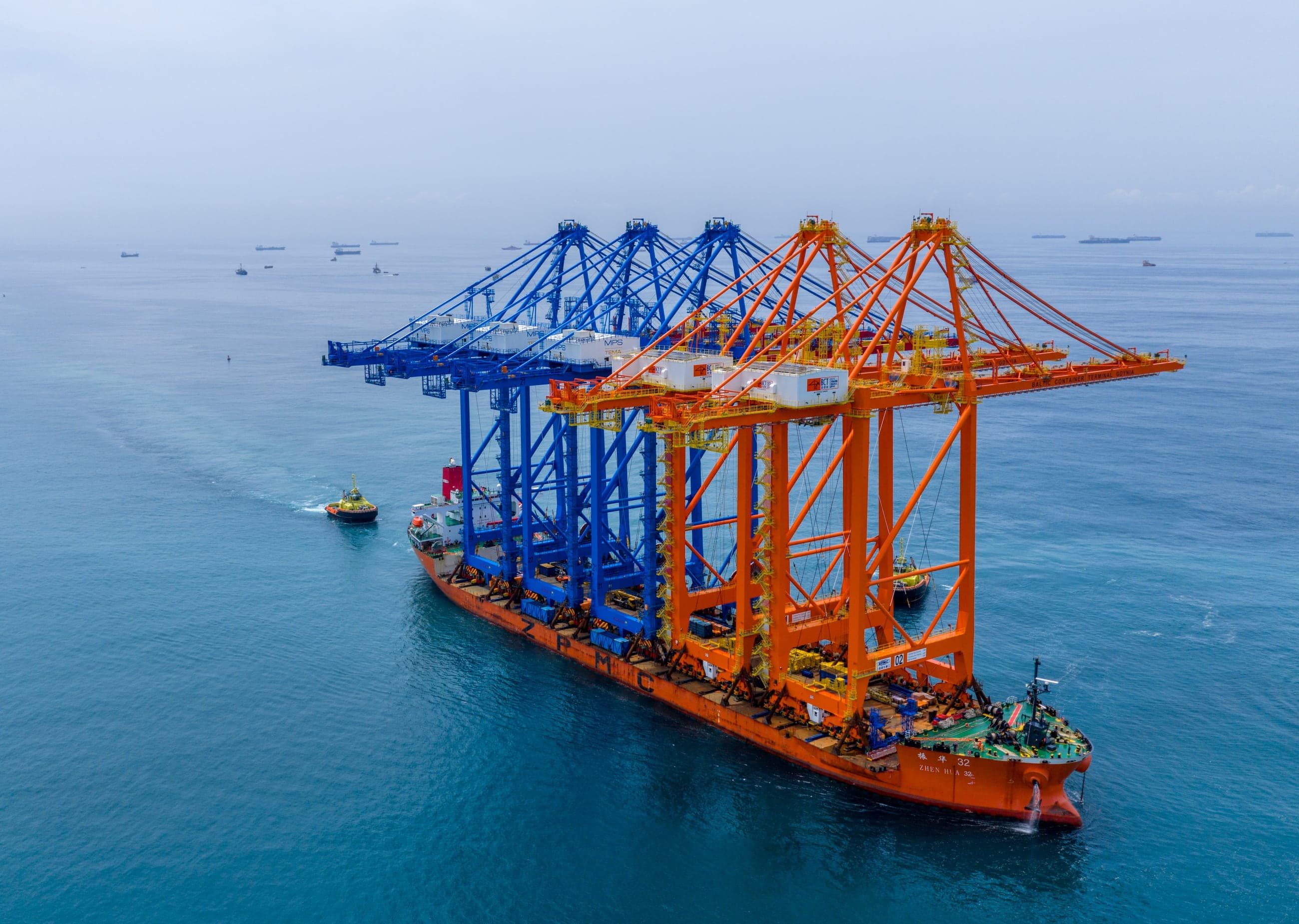 Drone photograph by Creat.ing: a heavy-lift ship carrying new blue and orange ship-to-shore cranes into Tema Port for Meridian Port Services